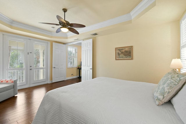 bedroom featuring access to outside, a tray ceiling, ceiling fan, and dark wood-type flooring