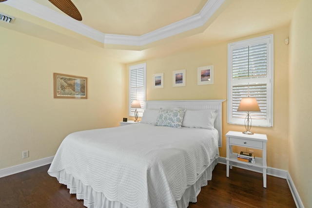 bedroom with ornamental molding, a raised ceiling, ceiling fan, and dark wood-type flooring