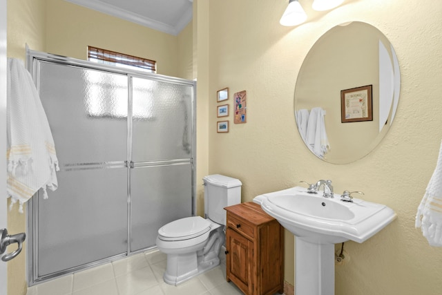 bathroom featuring tile patterned flooring, toilet, ornamental molding, and walk in shower