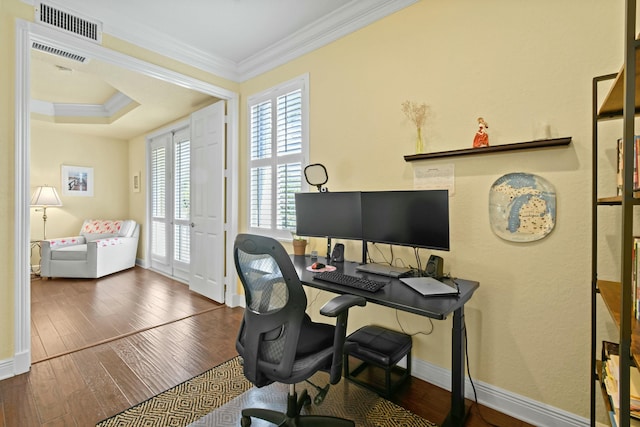 office with a raised ceiling, dark wood-type flooring, and ornamental molding