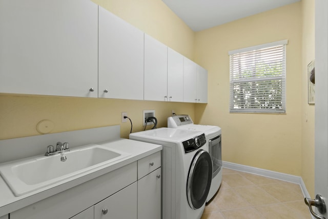 laundry room with cabinets, independent washer and dryer, light tile patterned floors, and sink