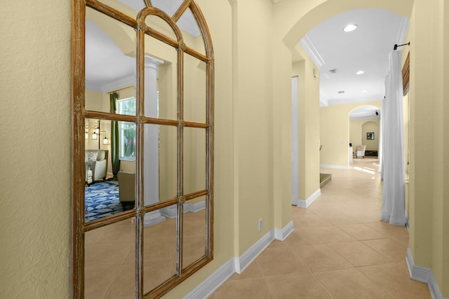 hallway featuring ornamental molding and light tile patterned flooring