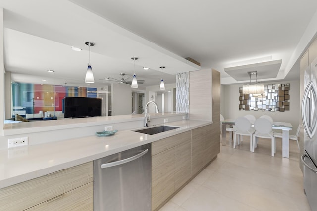 kitchen with sink, light tile patterned floors, appliances with stainless steel finishes, hanging light fixtures, and light brown cabinets