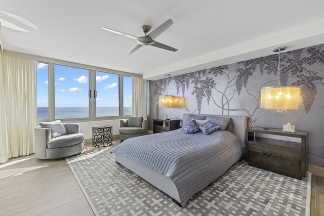 bedroom with a water view, ceiling fan, and light hardwood / wood-style flooring