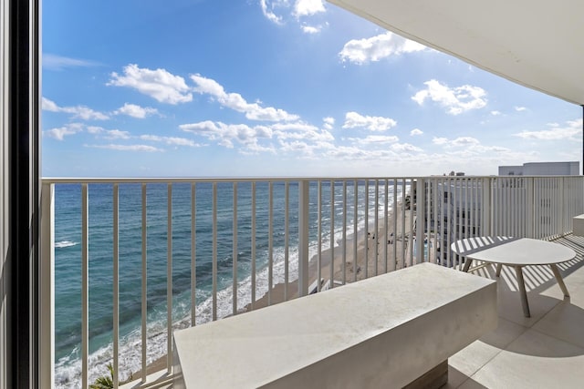 balcony featuring a view of the beach and a water view