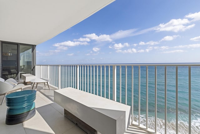 balcony featuring a water view and a view of the beach