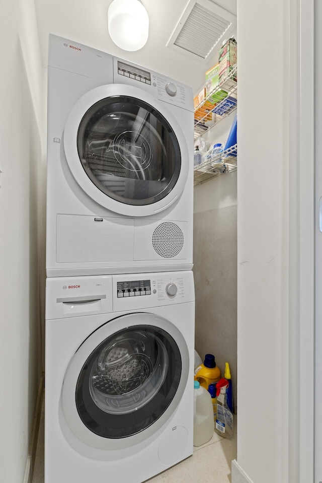 washroom featuring stacked washing maching and dryer