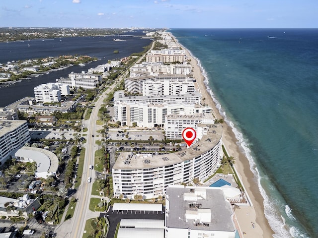 birds eye view of property with a water view and a beach view