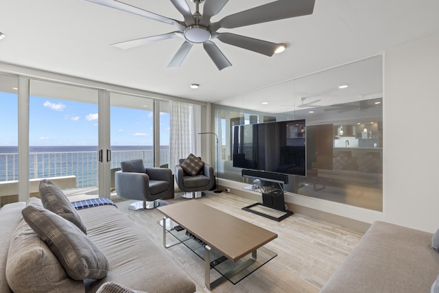 living room with light hardwood / wood-style floors, expansive windows, and ceiling fan