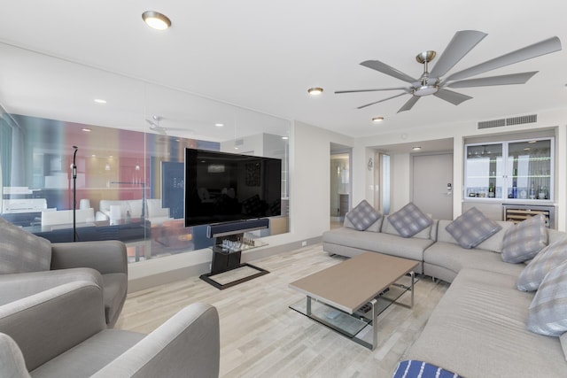 living room featuring light hardwood / wood-style flooring and ceiling fan