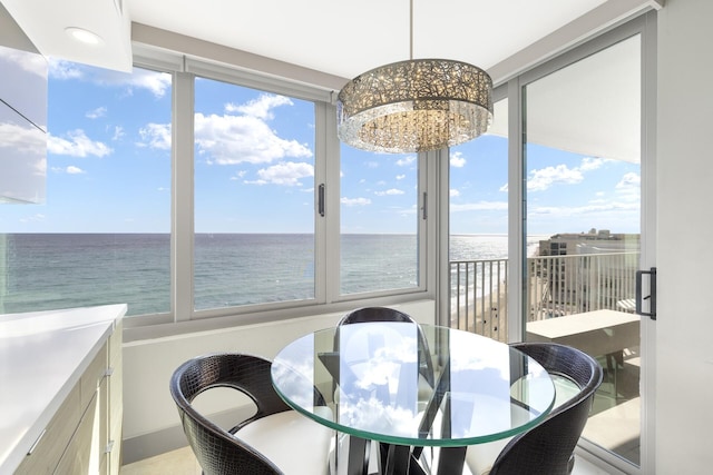 dining space with a water view and an inviting chandelier