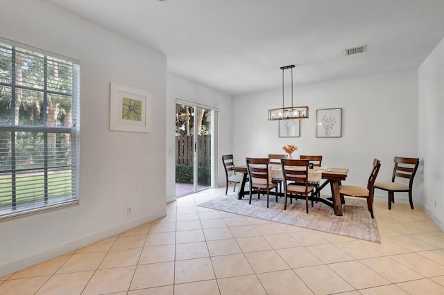 tiled dining space with a chandelier