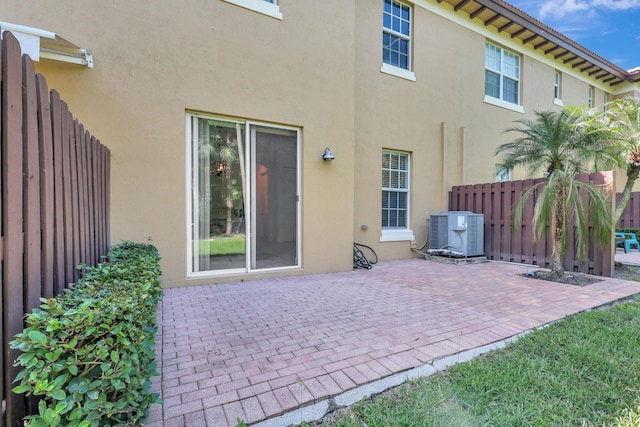 back of property with a patio and central AC