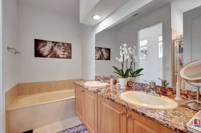 bathroom featuring tile patterned flooring, vanity, and a bathing tub