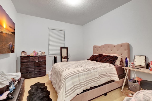 bedroom with light carpet and a textured ceiling