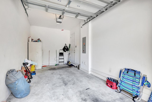 garage featuring white refrigerator and a garage door opener