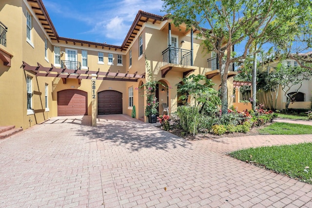 mediterranean / spanish-style house with a balcony and a garage