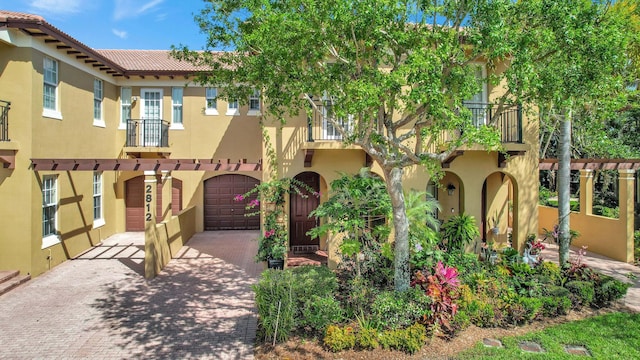 mediterranean / spanish-style house featuring a balcony and a garage