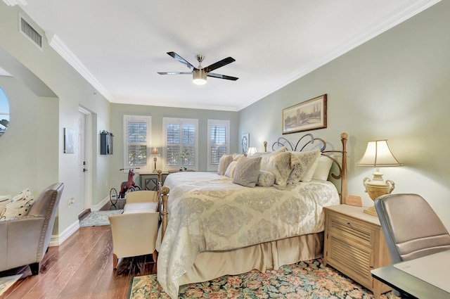 bedroom with ornamental molding, ceiling fan, and wood-type flooring