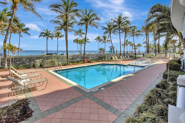 view of swimming pool featuring a patio and a water view