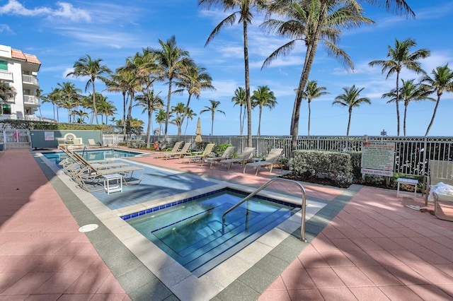 view of pool with a hot tub and a patio