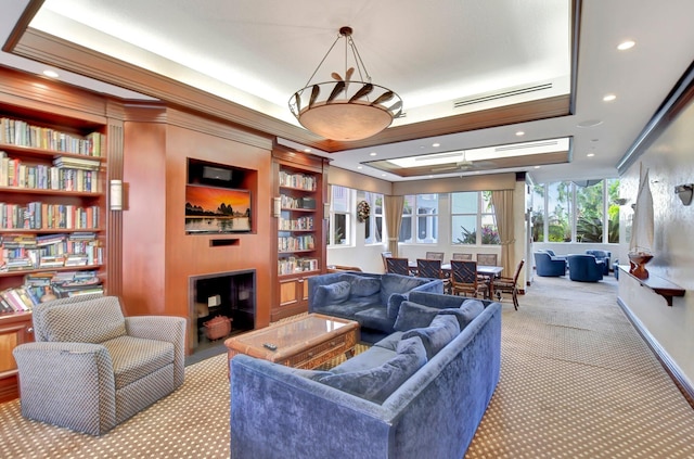 carpeted living room featuring crown molding and built in shelves