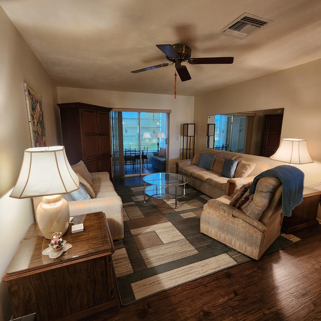 living room with ceiling fan and dark wood-type flooring