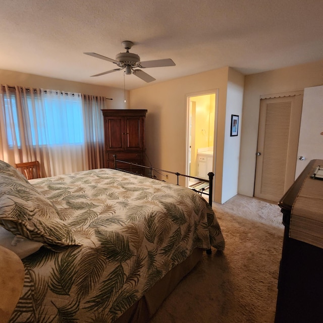 carpeted bedroom featuring ceiling fan and ensuite bath