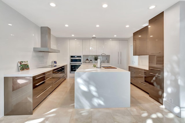 kitchen featuring white cabinetry, sink, wall chimney exhaust hood, stainless steel double oven, and black electric stovetop