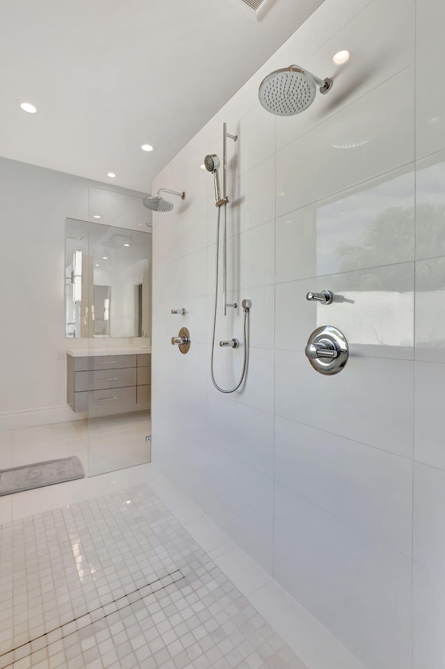 bathroom featuring a tile shower, vanity, and tile patterned floors