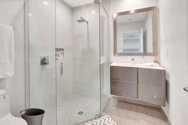 bathroom with vanity, an enclosed shower, and toilet