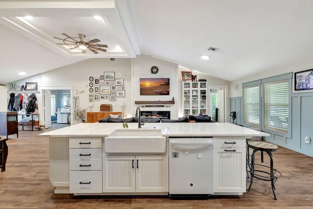 kitchen with ceiling fan, sink, a center island with sink, dishwasher, and white cabinetry