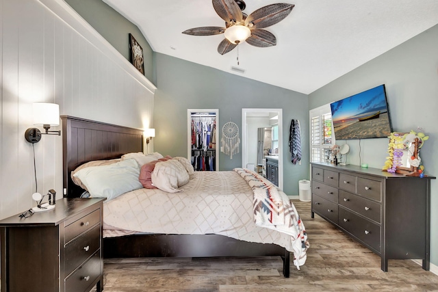 bedroom with a walk in closet, ensuite bathroom, ceiling fan, a closet, and lofted ceiling