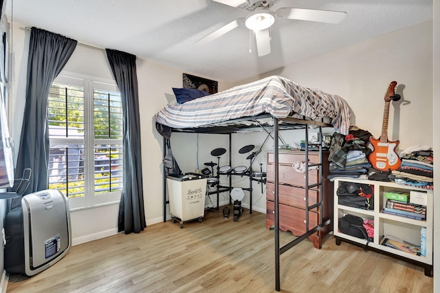 bedroom featuring hardwood / wood-style flooring, ceiling fan, and a textured ceiling