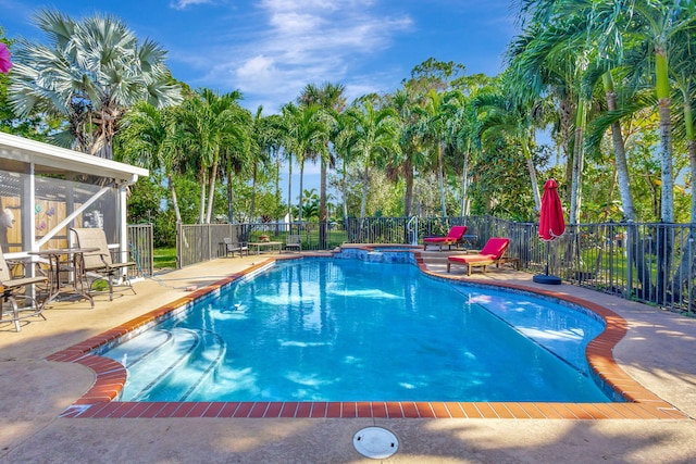 view of swimming pool with a patio and a sunroom