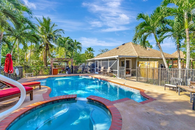 view of swimming pool with an in ground hot tub, a patio, and a sunroom