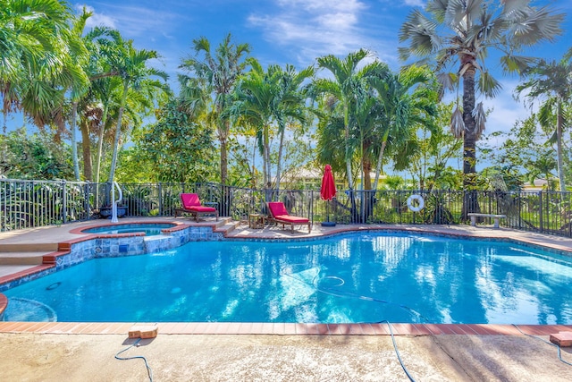 view of swimming pool featuring an in ground hot tub