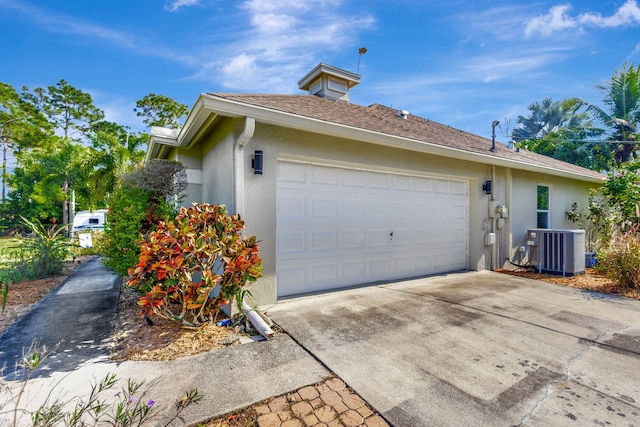 view of side of property featuring a garage and cooling unit