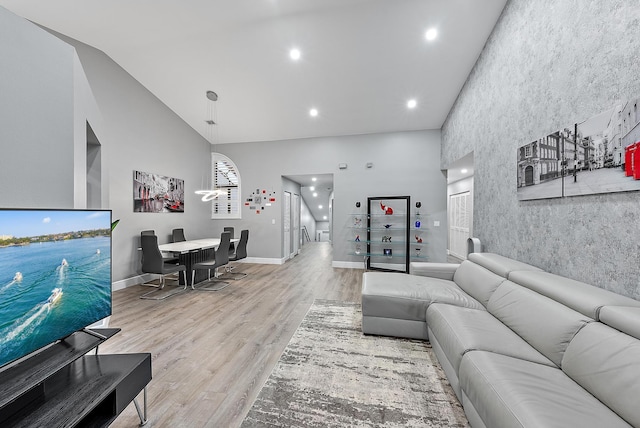 living room with high vaulted ceiling and light hardwood / wood-style floors