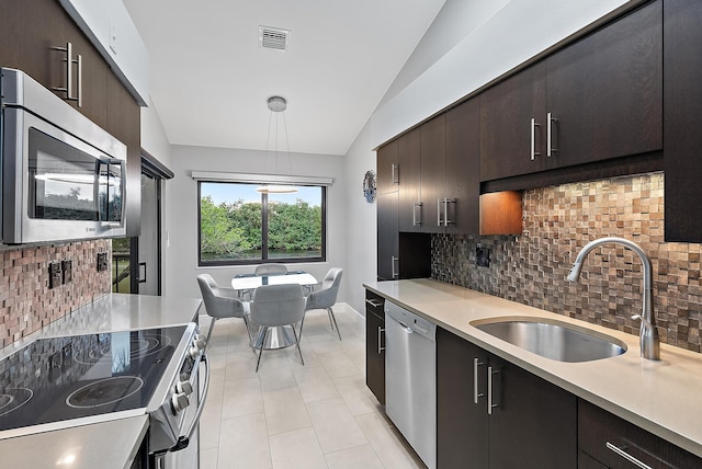 kitchen featuring lofted ceiling, sink, appliances with stainless steel finishes, tasteful backsplash, and dark brown cabinetry