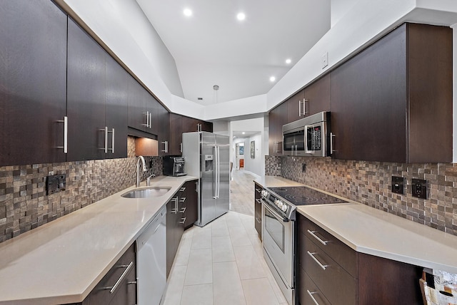 kitchen featuring decorative backsplash, sink, light tile patterned floors, and appliances with stainless steel finishes