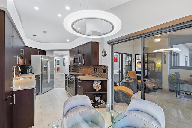 kitchen with appliances with stainless steel finishes, backsplash, dark brown cabinets, sink, and light tile patterned floors