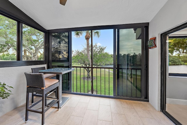 sunroom with ceiling fan and lofted ceiling