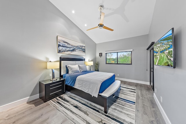 bedroom with ceiling fan, light hardwood / wood-style flooring, and high vaulted ceiling