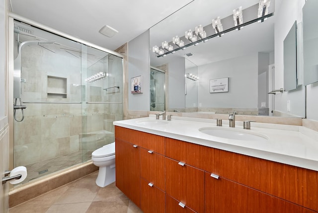 bathroom with tile patterned floors, vanity, toilet, and a shower with shower door