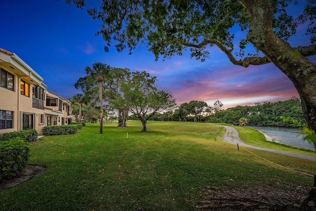 surrounding community with a lawn and a water view