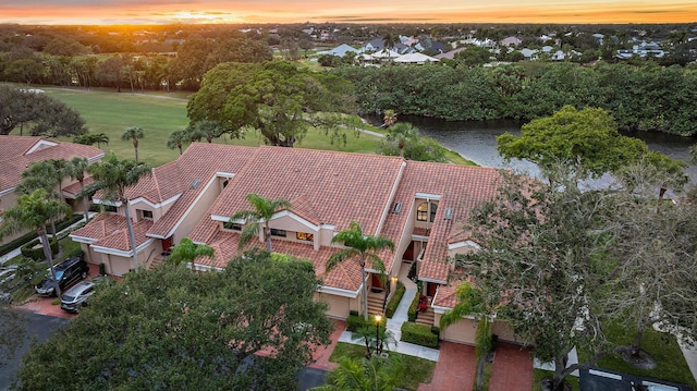 aerial view at dusk featuring a water view