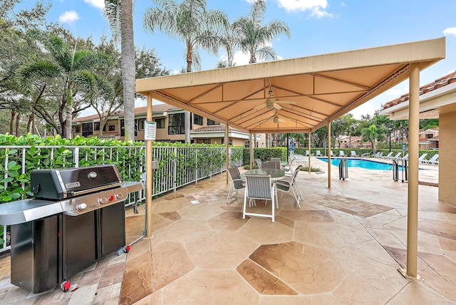 view of patio featuring a fenced in pool and area for grilling