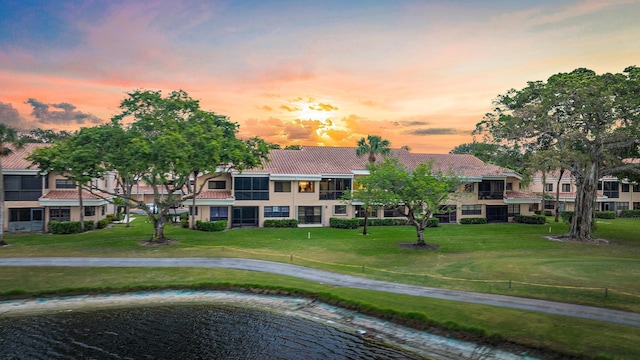 back house at dusk featuring a yard