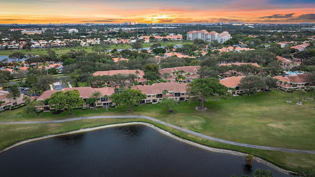 aerial view at dusk featuring a water view